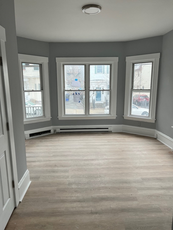 72 Bloomingdale Street, Unit 1 Chelsea, MA 02150 - Photo 5 of 6 an empty room with wooden floor and windows