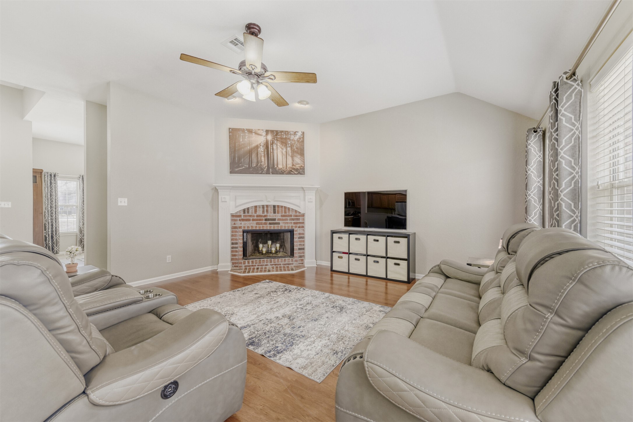 104 Spring Branch Bastrop, TX 78602 - Photo 13 of 32 Living room featuring wood finished floors, lofted ceiling, a brick fireplace, and a ceiling fan
