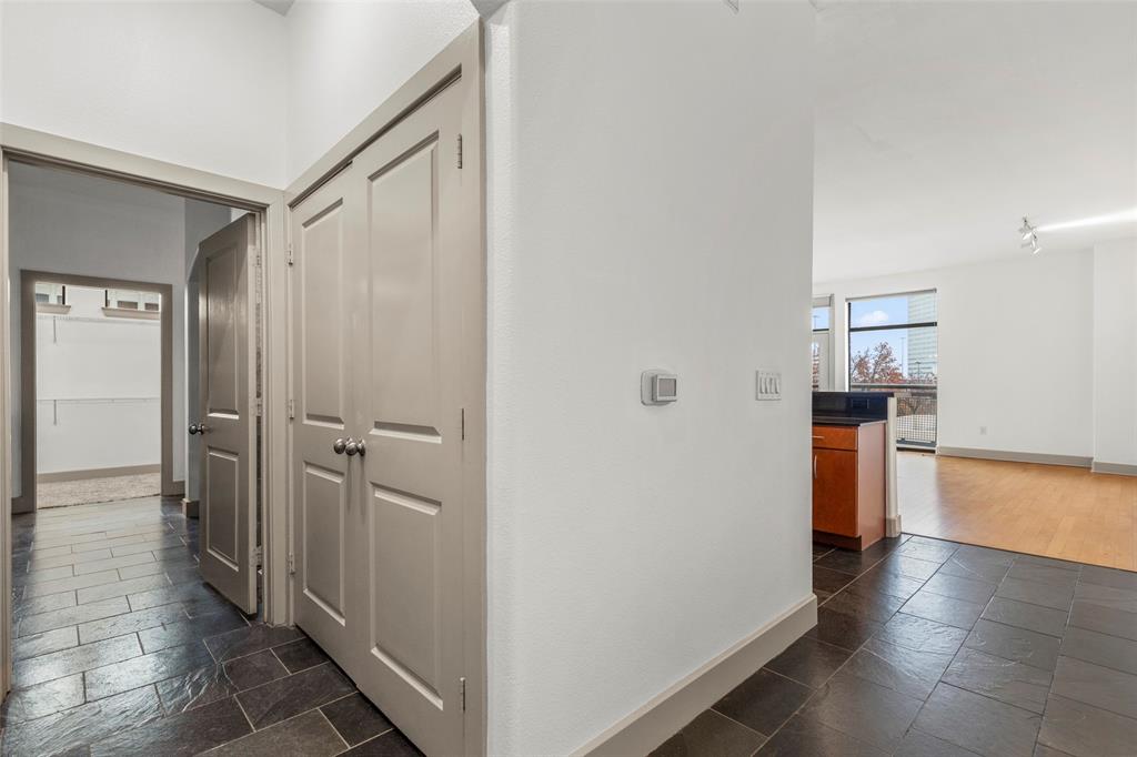 a view of a hallway with wooden floor and a bathroom