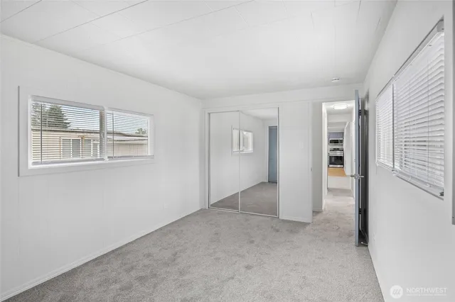 an empty room with windows and closet