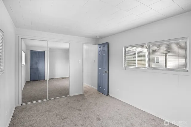 an empty room with windows and closet