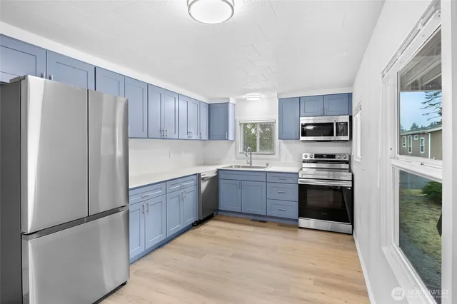 a kitchen with granite countertop stainless steel appliances a refrigerator a stove top oven a sink and dishwasher