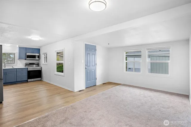 a view of an empty room with window and cabinet