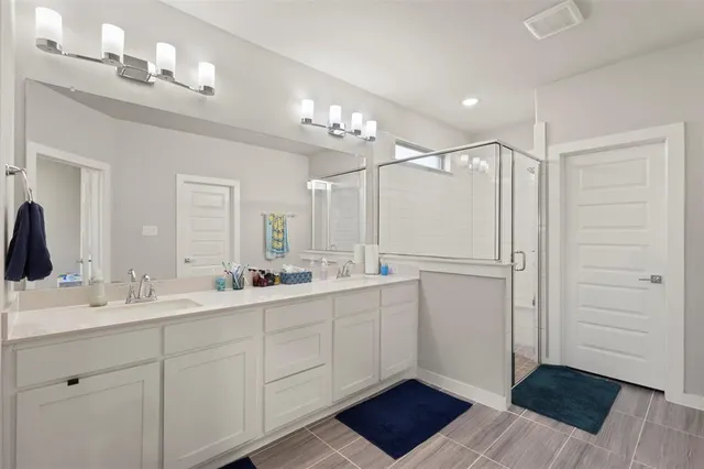 a bathroom with a double vanity sink a mirror and a shower