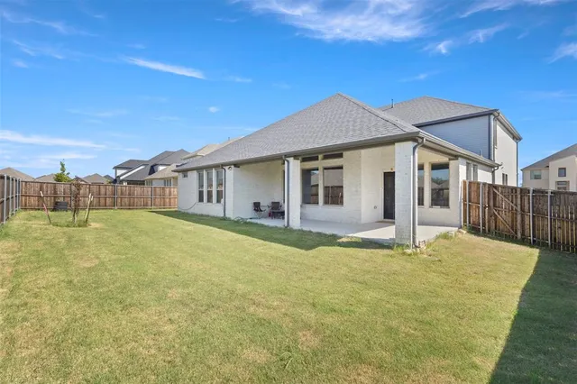 a backyard of a house with table and chairs