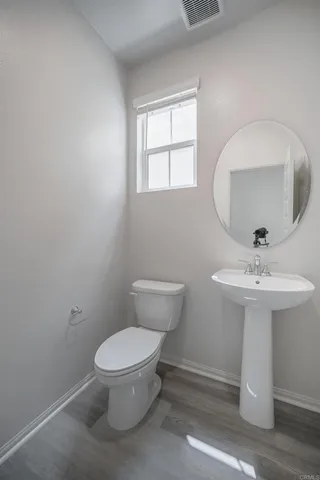 a bathroom with a toilet a sink and mirror