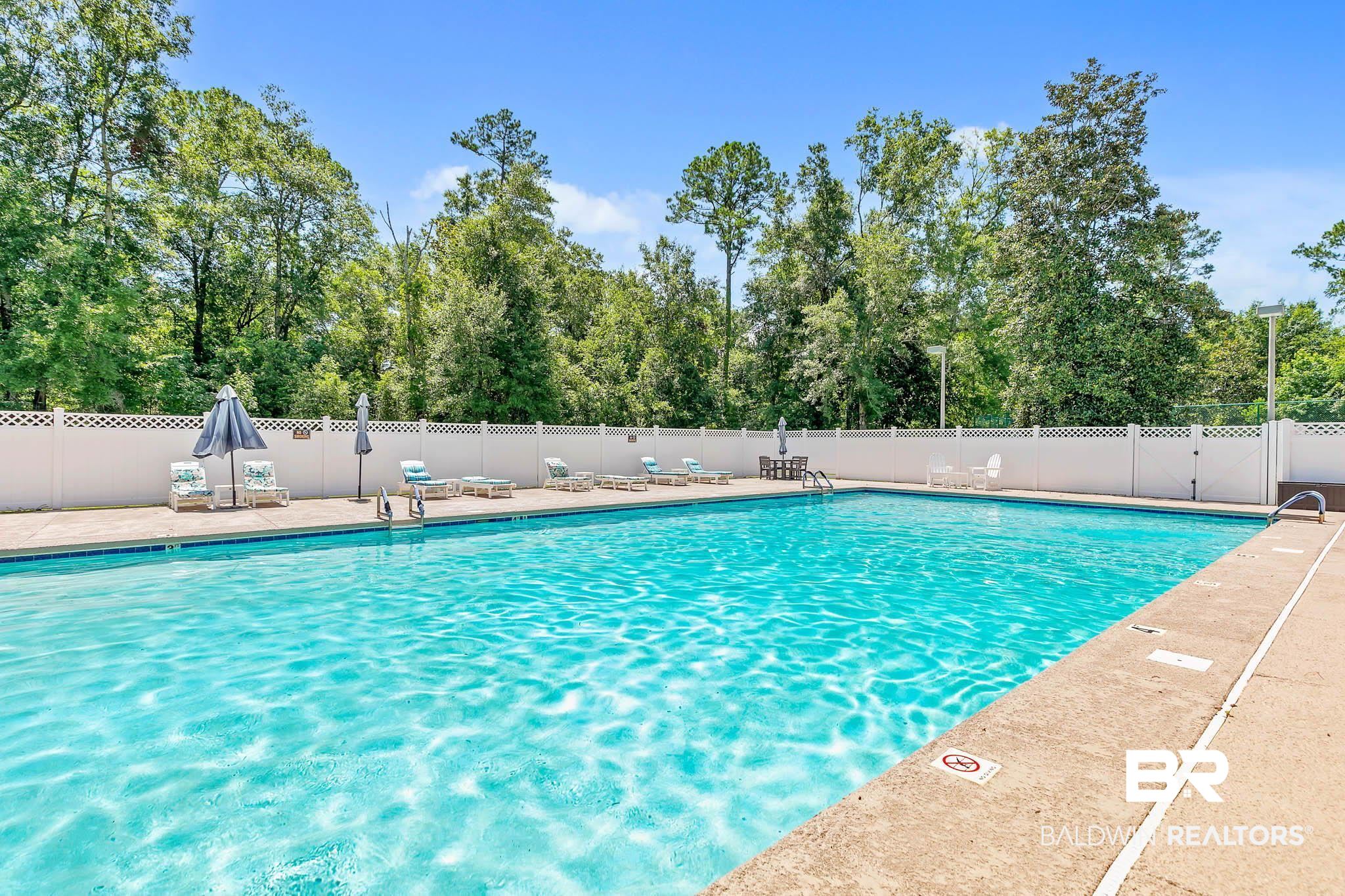 213 Hemingway Loop Foley, AL 36535 - Photo 52 of 69 Community pool featuring a patio area and view of scattered trees