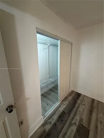 an empty room with wooden floor and a window