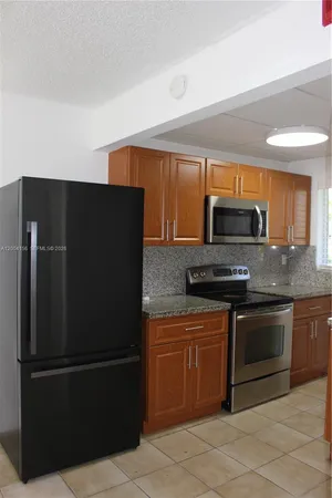 a kitchen with stainless steel appliances granite countertop a refrigerator and a stove top oven