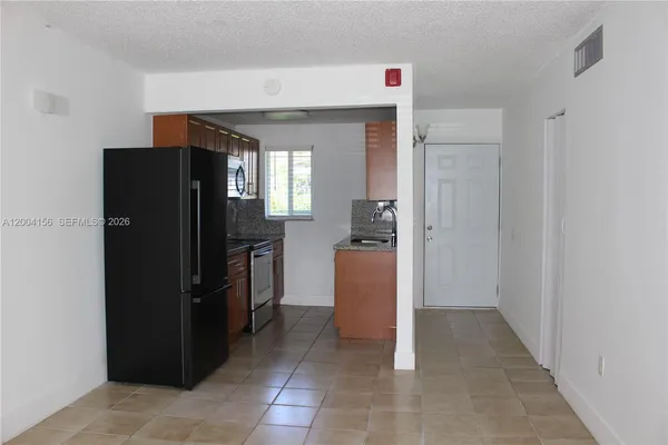 a kitchen with a refrigerator and a stove