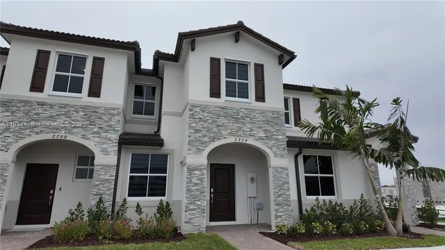 a front view of a house with plants