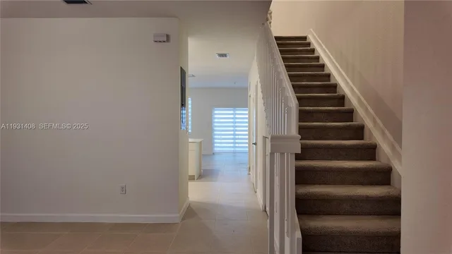 a view of staircase with white walls and a window