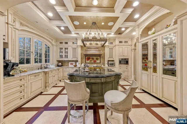 a view of a dining room with furniture a chandelier and kitchen view
