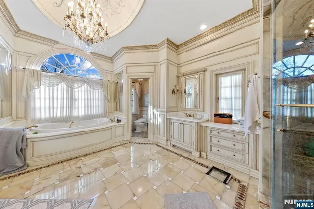 a bathroom with a tub sink shower and view living room