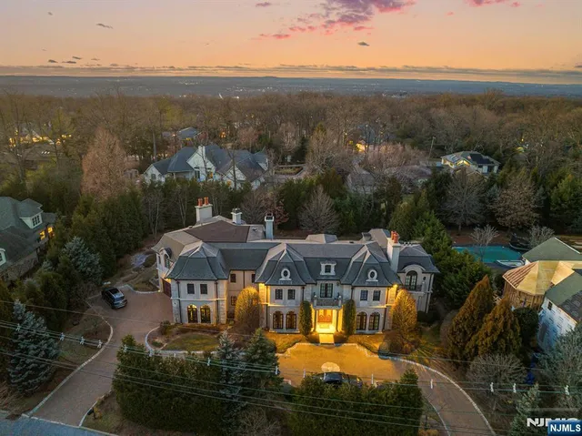 an aerial view of a house with garden space ocean and mountain view in back