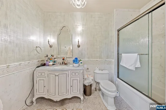 a bathroom with a sink a toilet a mirror and shower