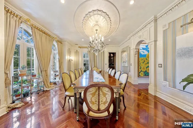 a view of a dining room with furniture a chandelier and wooden floor