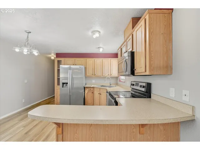 a kitchen with stainless steel appliances granite countertop a sink a stove and a refrigerator