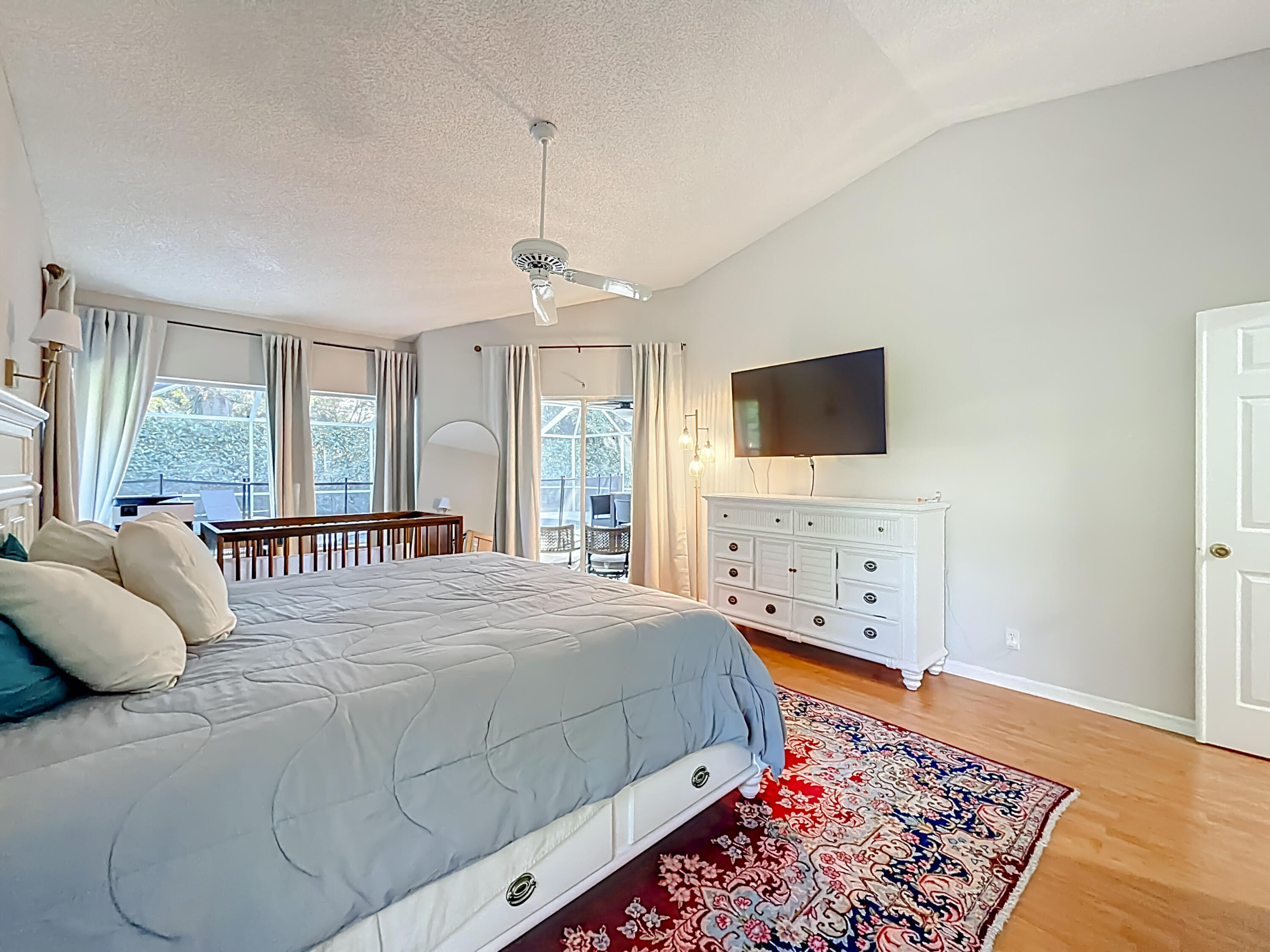 450 Northwest 53rd Street Boca Raton, FL 33487 - Photo 13 of 52 a bedroom with a large bed and a tv on dresser