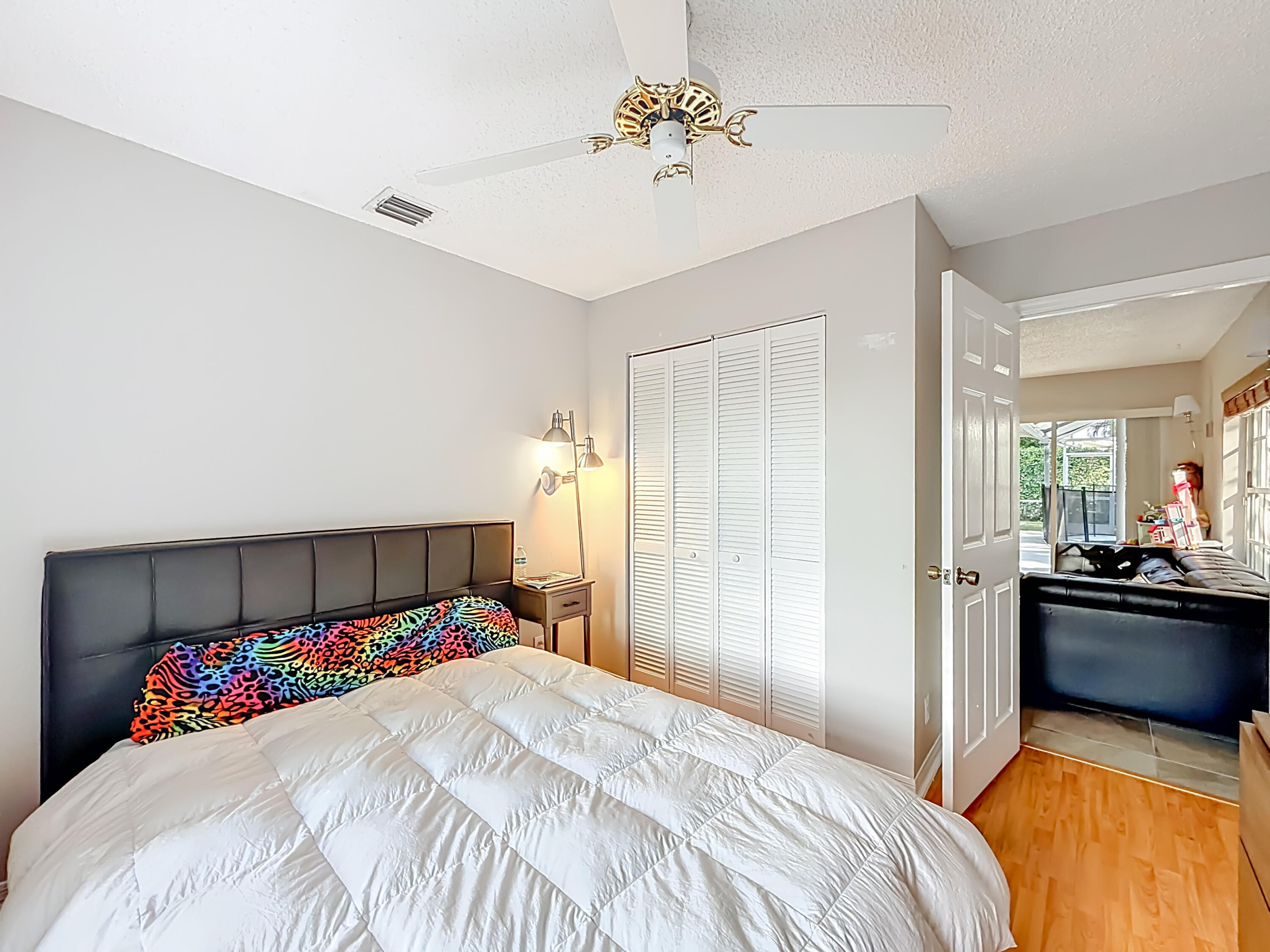 450 Northwest 53rd Street Boca Raton, FL 33487 - Photo 30 of 52 a bedroom with a bed and a chandelier