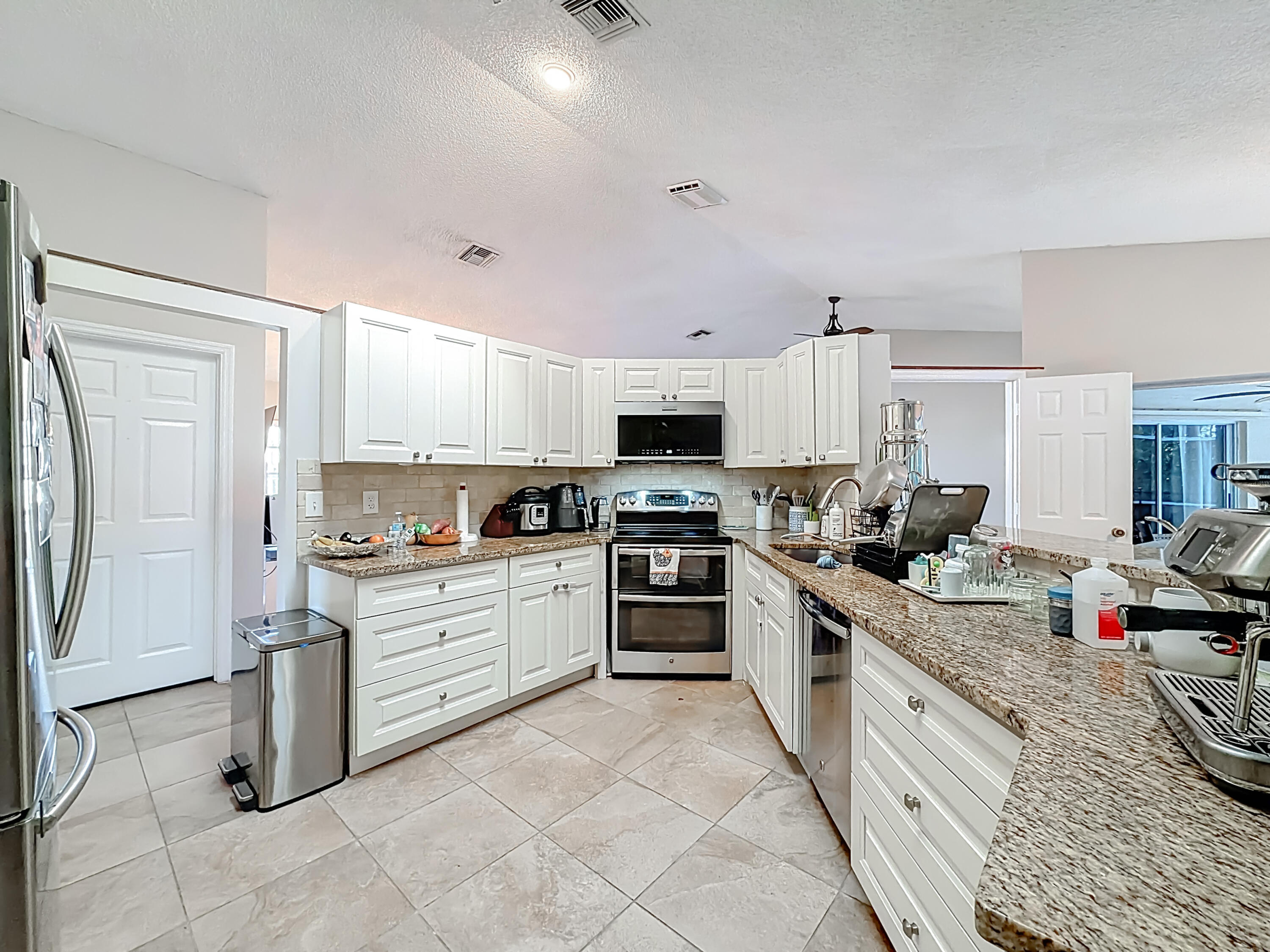 450 Northwest 53rd Street Boca Raton, FL 33487 - Photo 8 of 52 a kitchen with stainless steel appliances granite countertop a stove top oven a sink dishwasher and a refrigerator