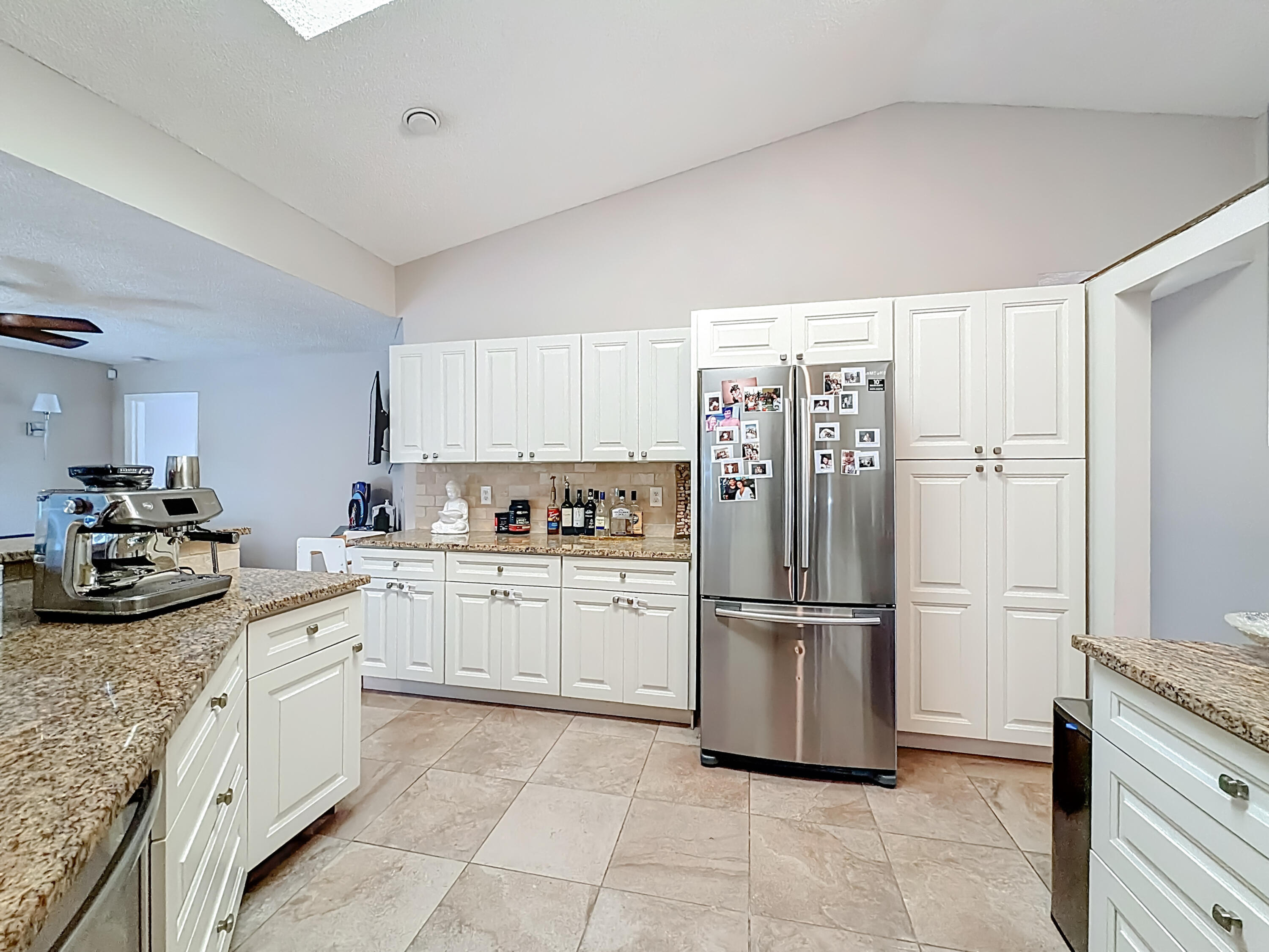 450 Northwest 53rd Street Boca Raton, FL 33487 - Photo 10 of 52 a kitchen with a refrigerator and cabinets