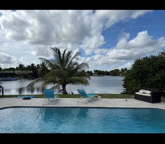 a view of swimming pool with a yard and lake view