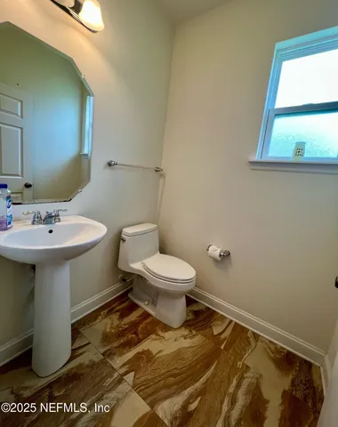 a bathroom with a sink toilet and a mirror