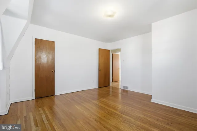 an empty room with wooden floor and closet
