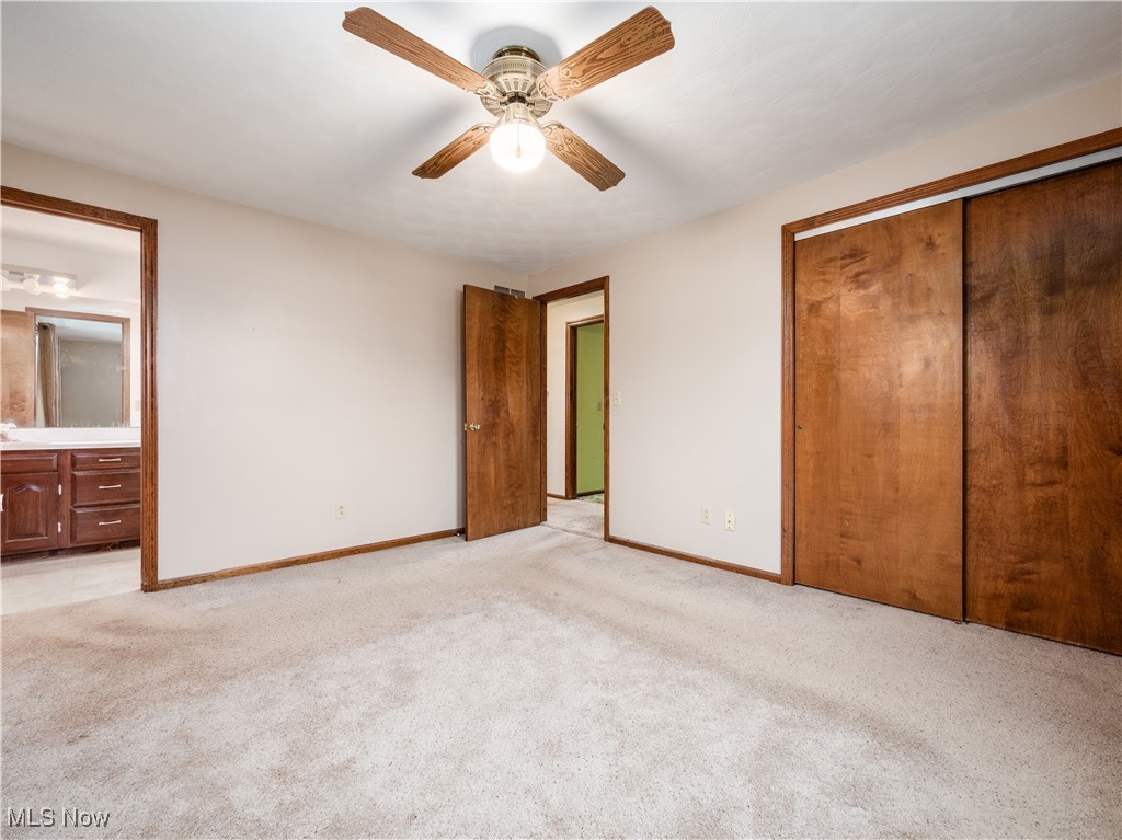 12454 Old Rainer Road Roseville, OH 43777 - Photo 16 of 33 Unfurnished bedroom with ceiling fan, a closet, ensuite bathroom, and light carpet