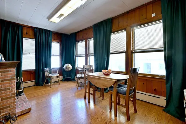a dining room with wooden floor a chandelier a glass table and chairs