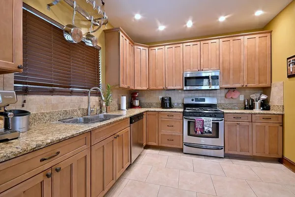 a kitchen with kitchen island granite countertop a sink stainless steel appliances and cabinets