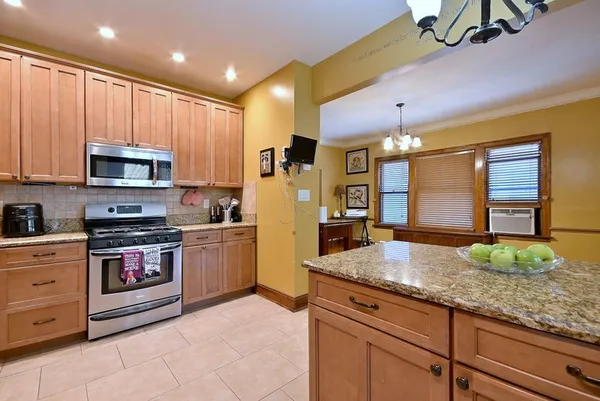 a kitchen with stainless steel appliances granite countertop a stove a sink and a microwave