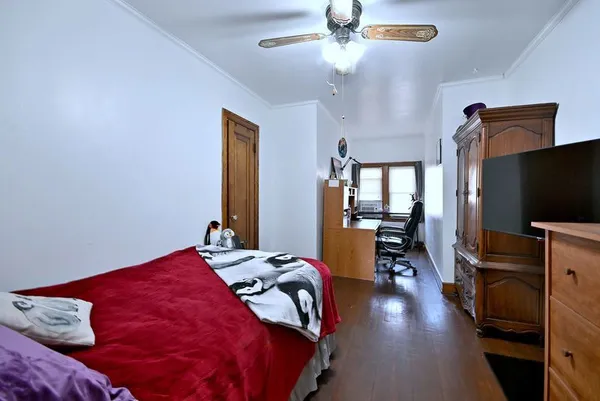 a bedroom with a bed and a flat tv screen on dresser