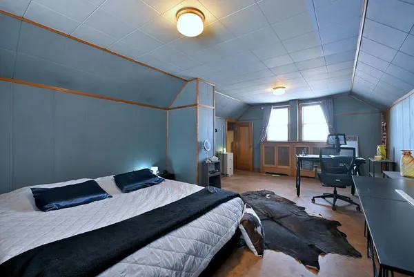 a bedroom with a bed and a large window
