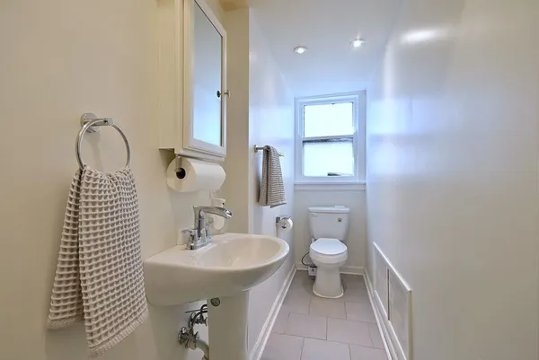 a bathroom with a sink a toilet and mirror