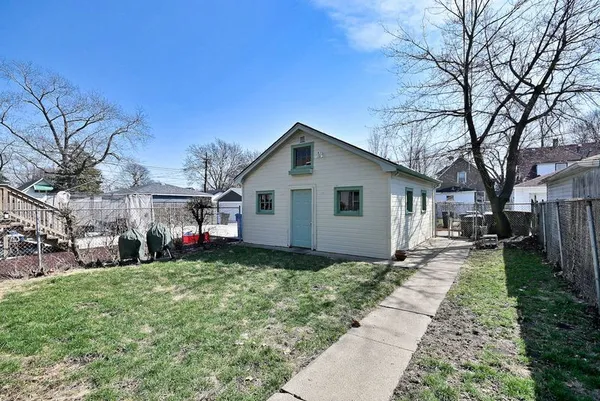 a front view of house with yard and trees around