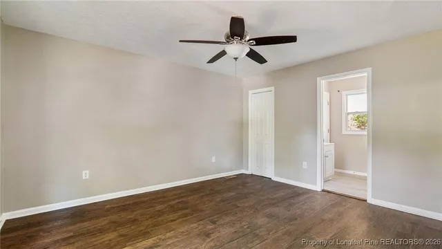 a view of a room with wooden floor and a ceiling fan