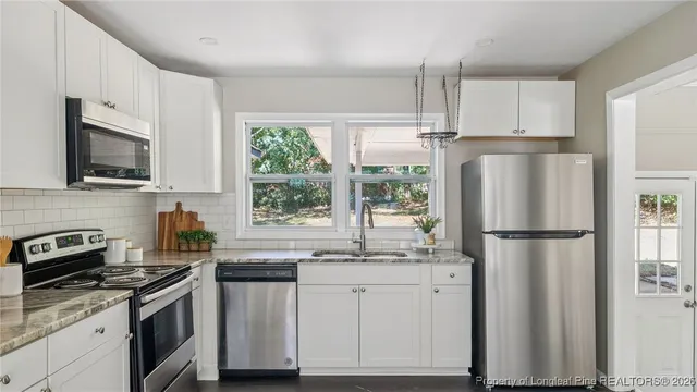 a kitchen with stainless steel appliances a refrigerator sink and microwave