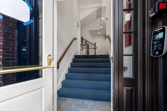 a view of staircase with lots of frames on wall and a window