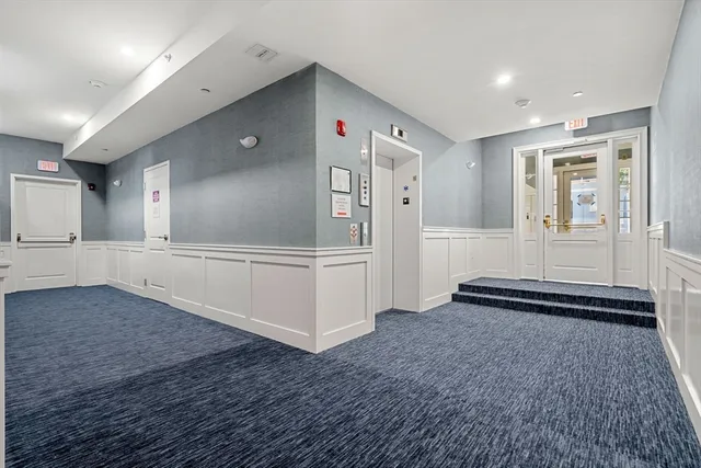 a view of a hallway with wooden cabinet