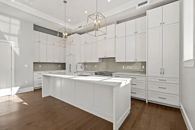 a kitchen with kitchen island white cabinets and white appliances