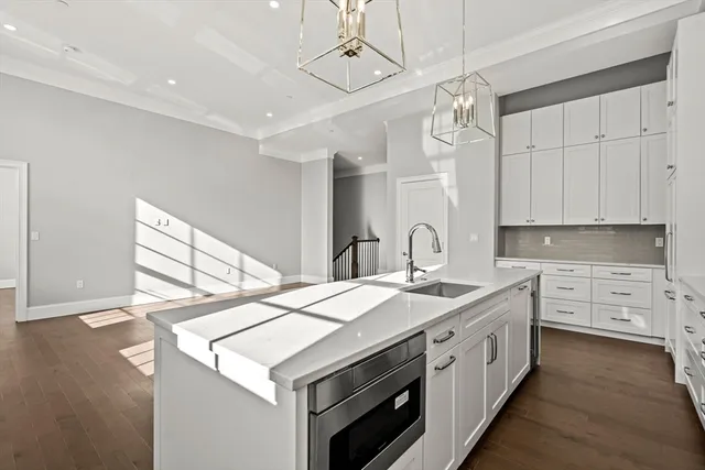 a kitchen that has a sink a stove and a wooden floor