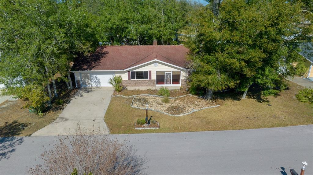 8639 Southwest 116th Lane Road Ocala, FL 34481 - Photo 1 of 1 an aerial view of a house with a yard and large trees