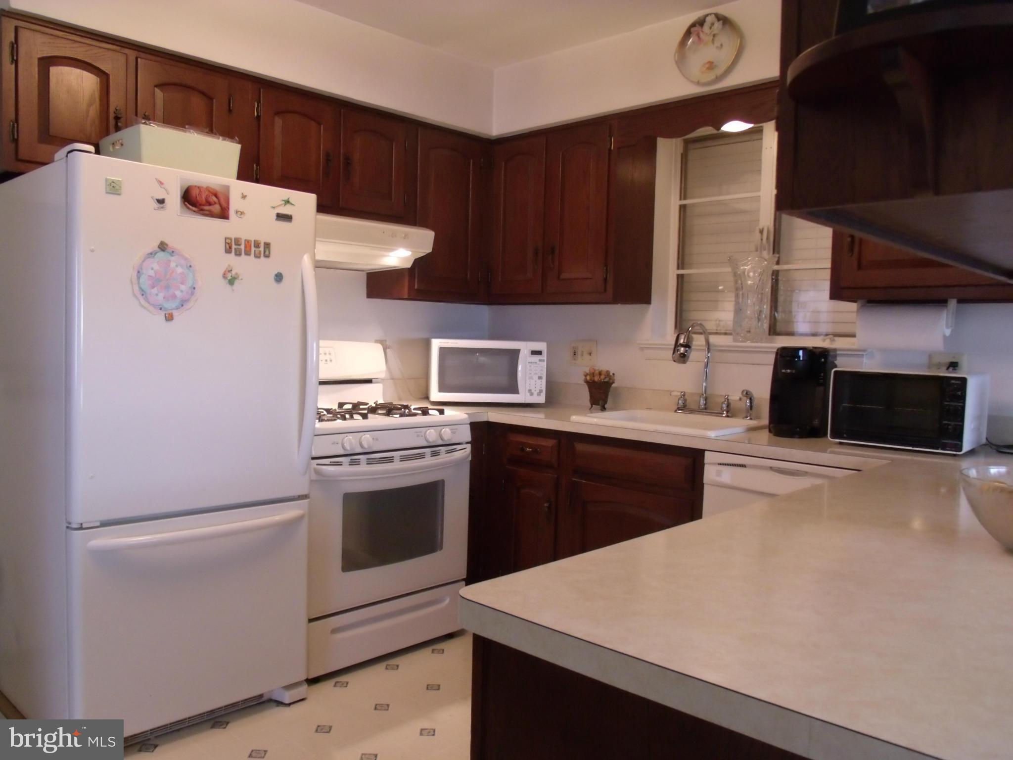 5214 Light Street Springfield, VA 22151 - Photo 11 of 27 a kitchen with stainless steel appliances a refrigerator sink and white cabinets