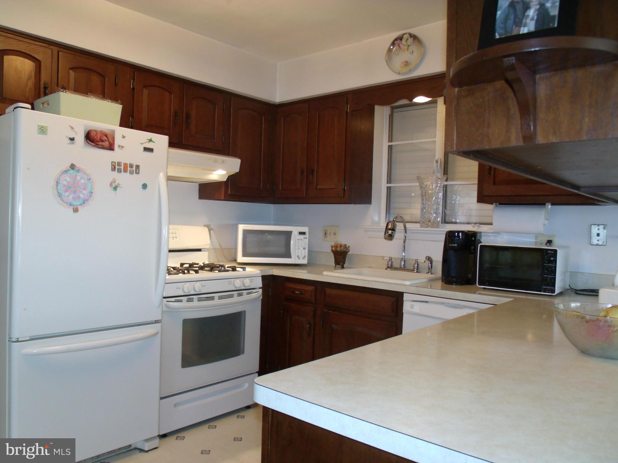5214 Light Street Springfield, VA 22151 - Photo 12 of 27 a kitchen with a stove a microwave and a refrigerator