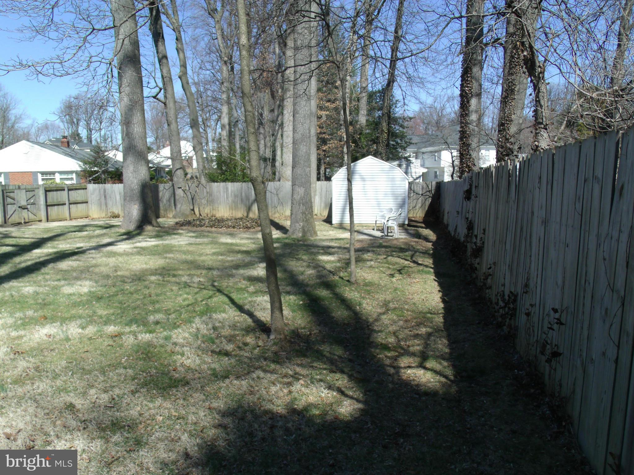 5214 Light Street Springfield, VA 22151 - Photo 27 of 27 a backyard of a house with table and chairs under an umbrella