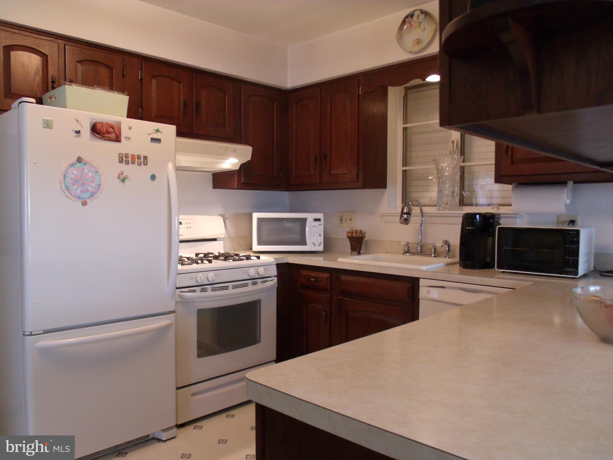5214 Light Street Springfield, VA 22151 - Photo 10 of 27 a kitchen with a white stove top oven and refrigerator