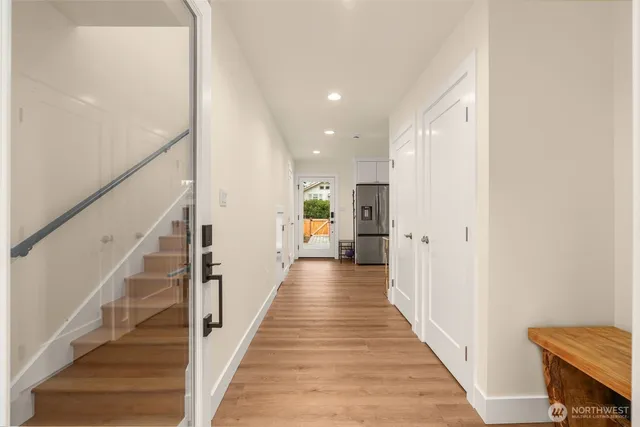 a view of a hallway with wooden floor and staircase