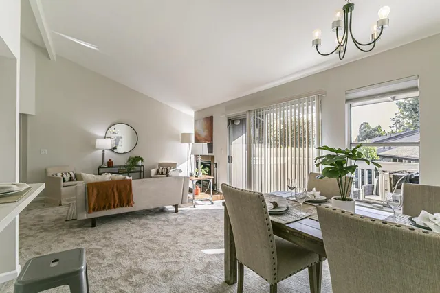 a living room with furniture chandelier and a window
